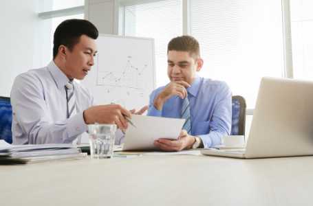 Dentist and marketing consultant discussing Invisalign sales strategies in an office